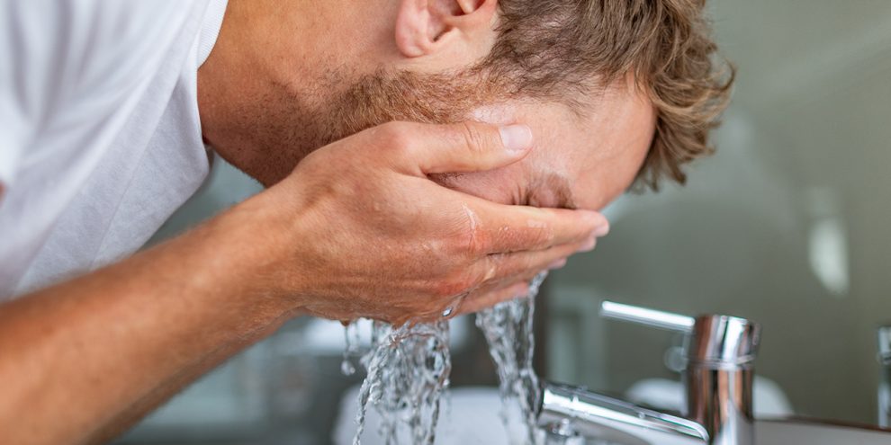 man washing face